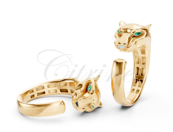 Gold ring featuring sculpted panther heads with green gemstone eyes and white nose details