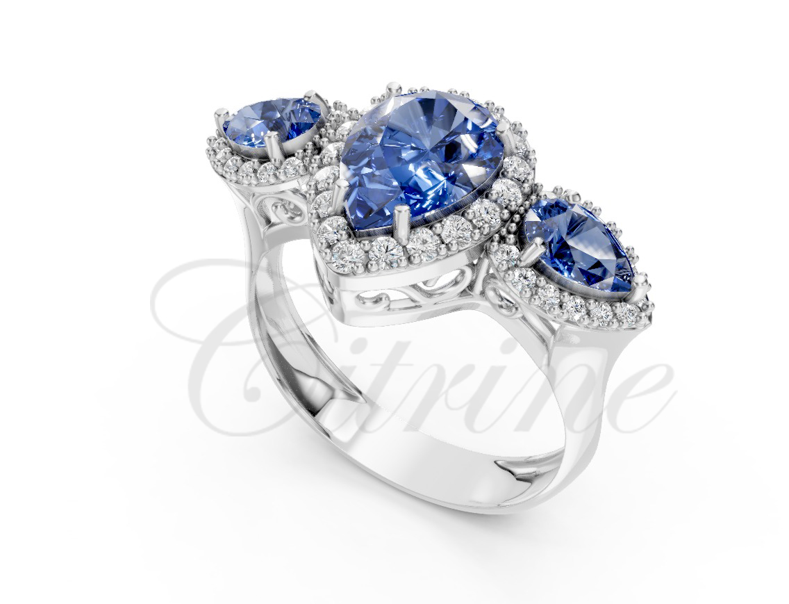 Three pear-cut blue sapphire ring with diamond halos set in white metal.