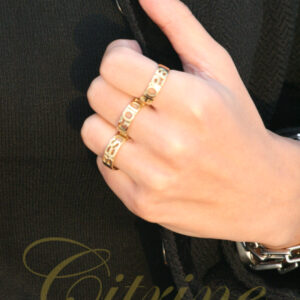 Gold rings with the words HOPE and BEST in openwork design worn on hand