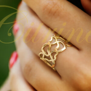 Gold ring with openwork interlocking hearts design worn on hand