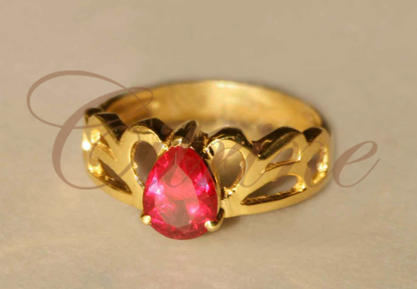Gold ring with pear-shaped red gemstone and cut-out band by Citrine Jewellery
