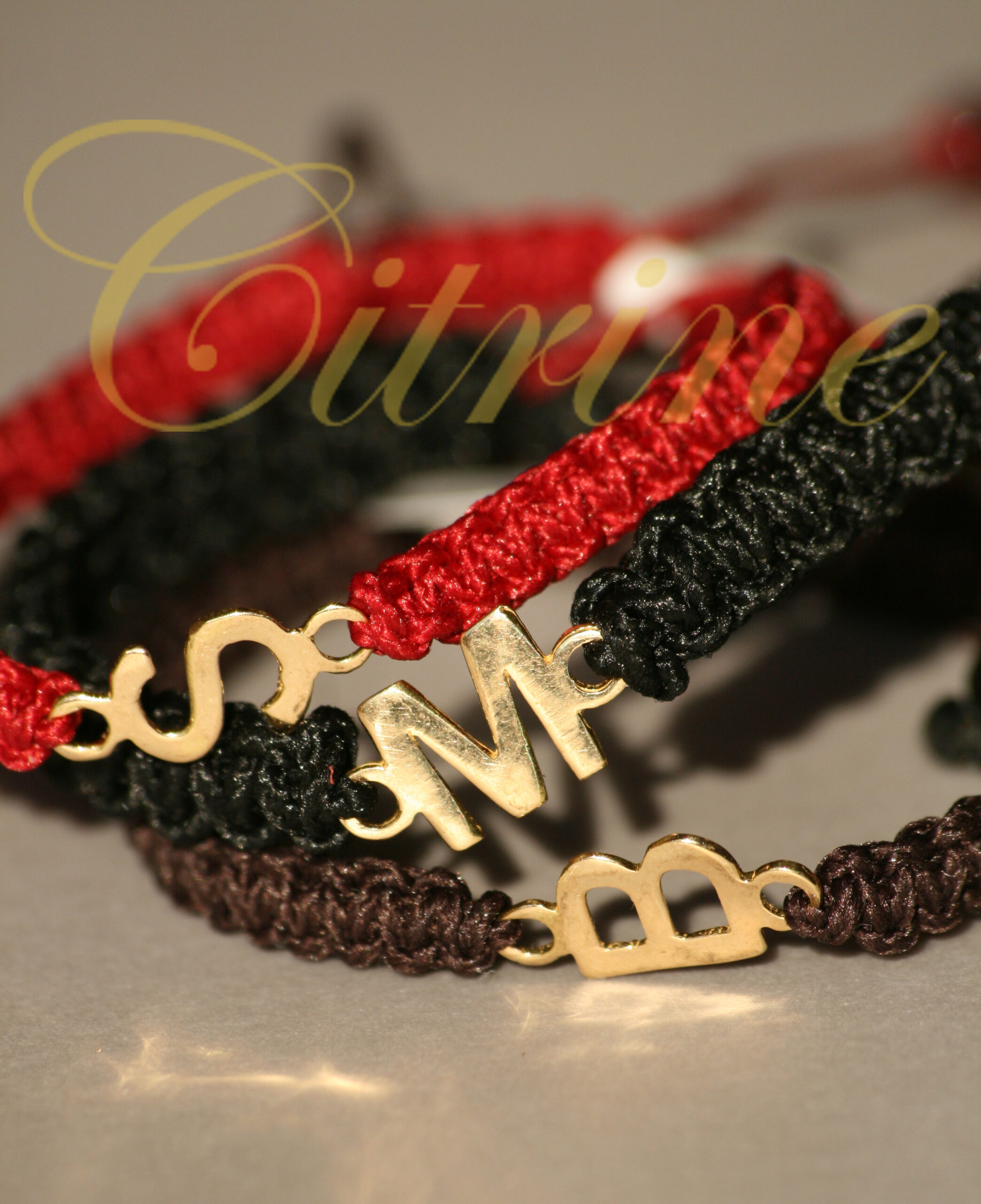 Handmade macrame bracelets with gold-tone initials.