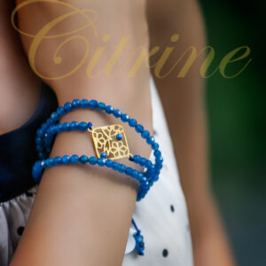 Handmade bracelet with blue beads and gold filigree charm.