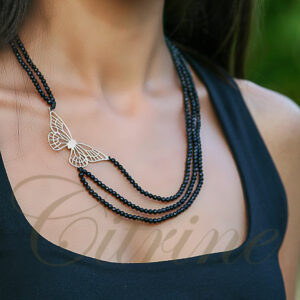 Handmade necklace with butterfly pendant and black beaded strands.